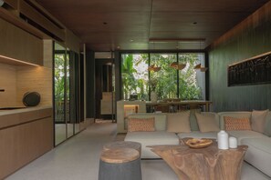 A modern living room with a sofa, coffee table, and wooden accents. - The Akasha Berawa Luxury Villas (Tibubeneng)