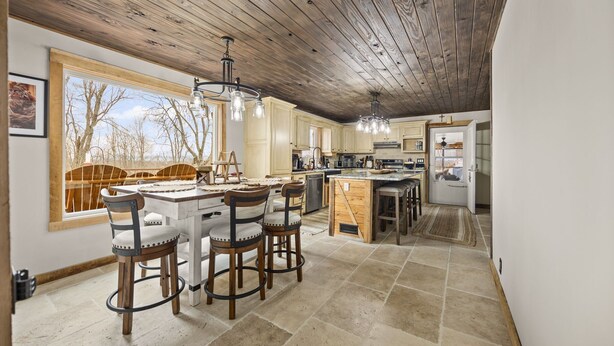 Una cocina amplia con techo de madera, ventanas grandes y una isla central.