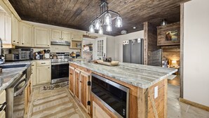 Una cocina con armarios de madera, encimera de mármol y lavavajillas integrado.