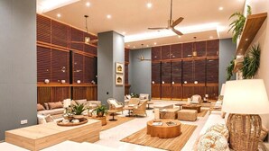 A modern lounge area with wooden slatted walls, comfortable seating, and ambient lighting. - Beachfront apartment - Resort style (Santa Marta)