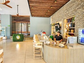 A modern bar area with a wooden ceiling, a stone accent wall, and a bar counter with various items. - Beachfront apartment - Resort style (Santa Marta)