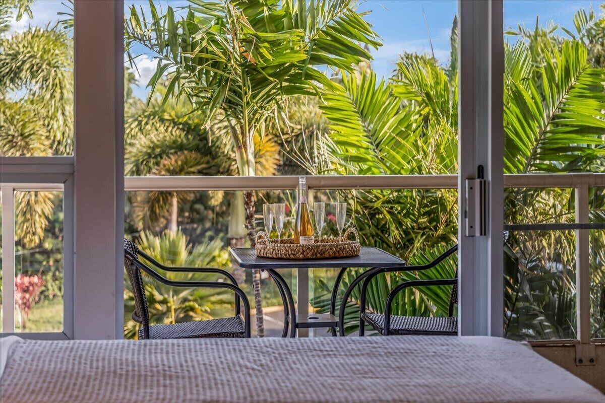 A balcony with a table set for four, surrounded by lush greenery.