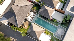 Vista aerea di un resort con piscina, diverse zone relax e un giardino curato.