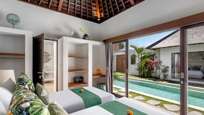 Camera d'albergo moderna con vista piscina, un letto grande, un armadio a muro e una porta scorrevole in vetro verso la piscina.