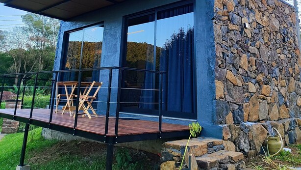 A modern building with a stone exterior, large windows, and a wooden deck. - Cabin in the countryside of Nova Petrópolis, Serra Gaúcha - Chacara Villagio das Pedras (Nova Petrópolis)