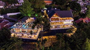 Una casa grande de varios pisos con piscina y varios balcones.