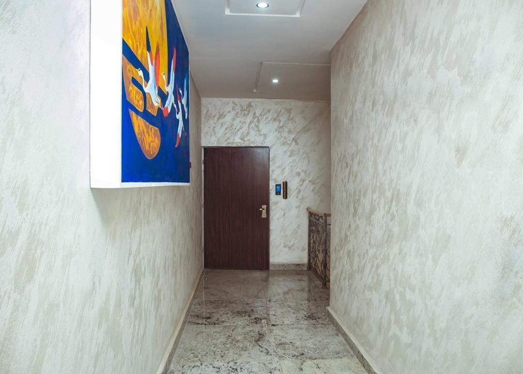 A hallway with marble walls and a wooden door at the end.