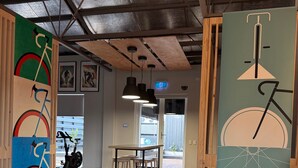 A modern room with a white sofa, a dining area with a table and chairs, and artwork on the walls. - Entire Private Lodge for Exclusive Use-Perfect for Groups (Normanville)