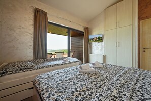 A bedroom with two beds, a large window, and a view of the outdoors. - Modern villa for 5 with indoor pool, jacuzzi, sauna, and barbecue (Marija Bistrica)