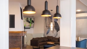 A modern living room with a sectional sofa, a round coffee table, and pendant lighting. - Luxury villa with jacuzzi, sauna and pool surrounded by vineyards (Požega)