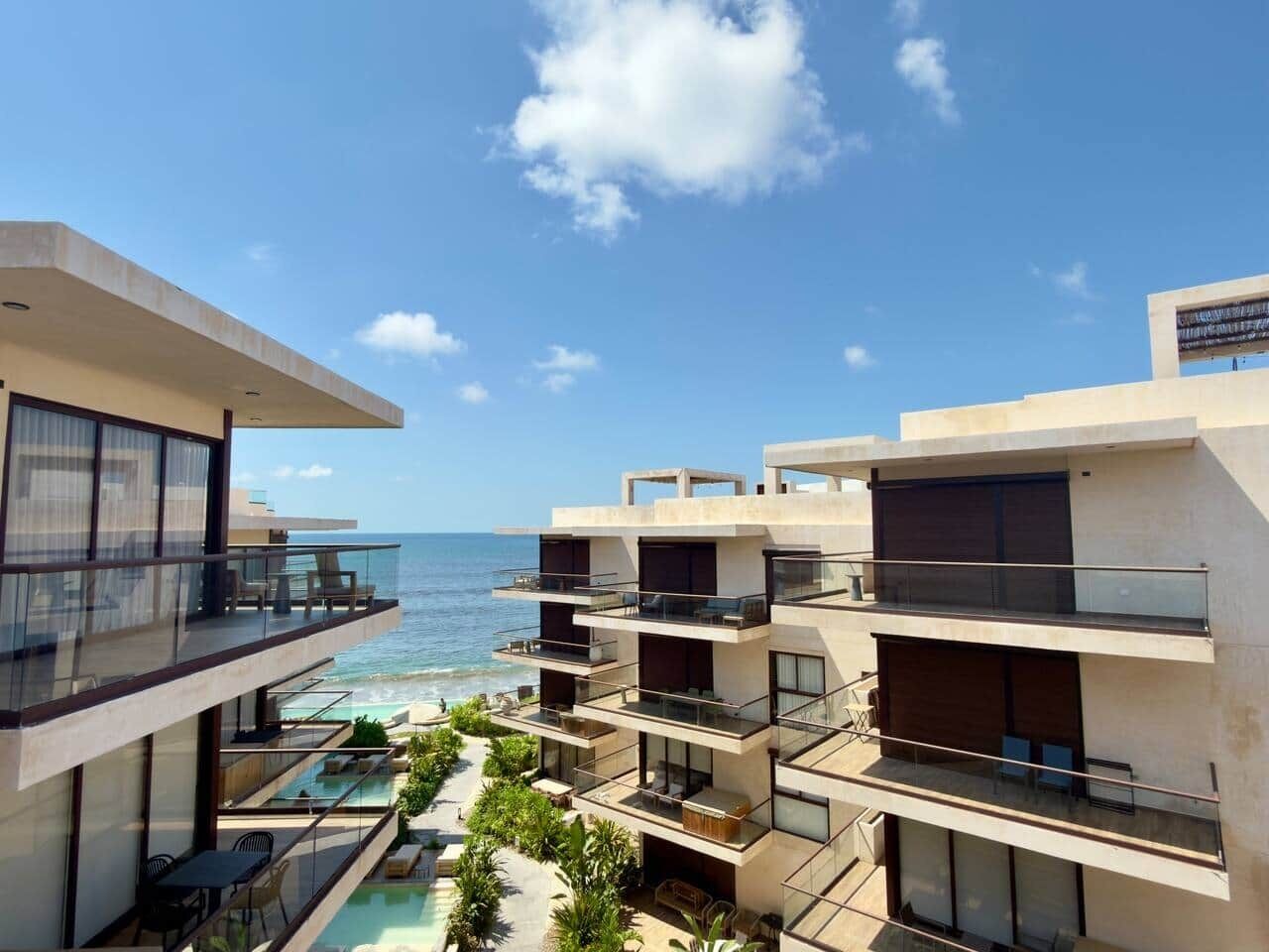Ein modernes Hotel mit mehreren Balkonen mit Blick auf einen Pool und den Ozean.