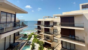 Ein modernes Hotel mit mehreren Balkonen mit Blick auf einen Pool und den Ozean.