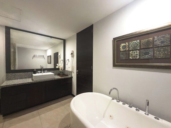 A modern bathroom with a freestanding bathtub, a large mirror, and a vanity with a sink.