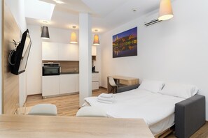 Et moderne hotelværelse med seng, skrivebord og tekøkken.