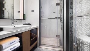 A modern bathroom with a glass-enclosed shower, a white sink, and a mirror. - Hampton by Hilton Xiamen Tong'an Chengnan (Xiamen)