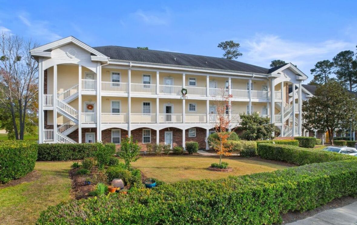 A multi-story hotel with a central courtyard, balconies, and a brick facade.