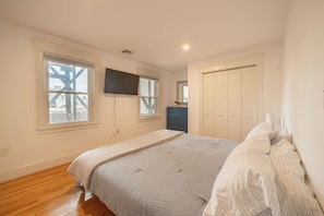 A bedroom with a bed, a dresser, a TV mounted on the wall, and a closet. - World Cup ready. with AC, beaches, Boston, and Salem (Melrose)