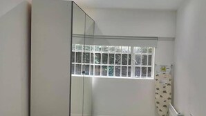 A modern bedroom with a large mirror, a window, and a radiator. - Kings Cross 1 Bedroom Apartment (London)