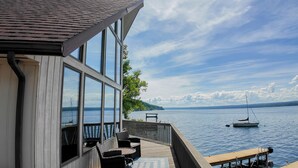 Een pand aan het water met een terras, zitplaatsen buiten en uitzicht op het water.
