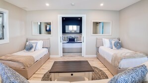Een slaapkamer met twee bedden, een tafeltje en een spiegel.
