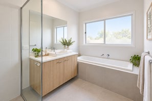A modern bathroom with a glass shower enclosure, a sink with a mirror, a bathtub, and a window providing natural light. - Serene 4-bedroom house with AC in charming Park Ridge (Park Ridge)
