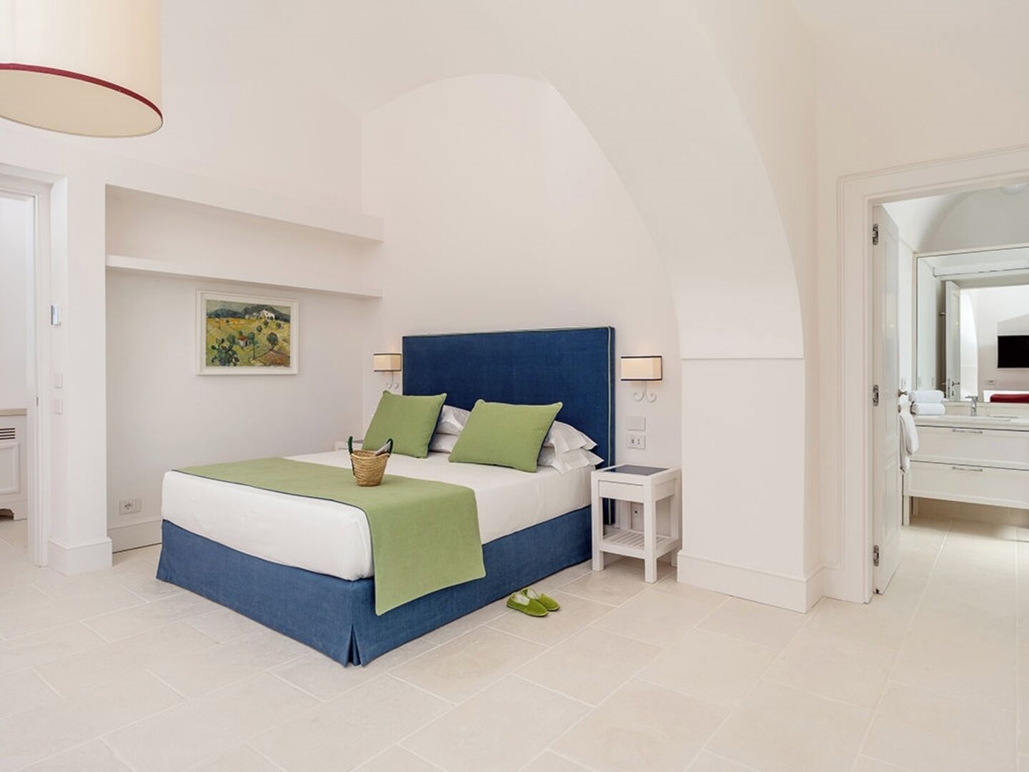 A bedroom with a bed, bedside table, and a mirror.
