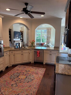 A spacious kitchen with a granite countertop, a ceiling fan, and a large window providing natural light. - Perfect Masters Rental - 5-bedroom/3.5 bath home in Evans. Easy commute to ANGC (Evans)