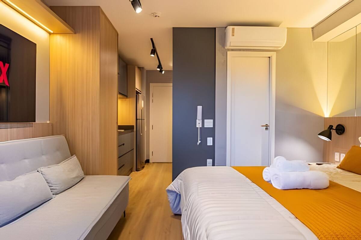Habitación de hotel con cama, sofá, armario y baño.