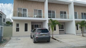 Ein modernes, zweistöckiges Wohnhaus mit einem geparkten Auto davor.