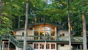 Eine zweistöckige Hütte mit Balkon und Treppe.