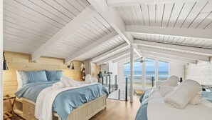 Un dormitorio con una cama grande, otra cama y vista al océano.