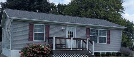 A single-story house with a front porch, a small deck, and a well-maintained lawn.