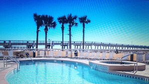 Ein Poolbereich mit Liegestühlen und Palmen.