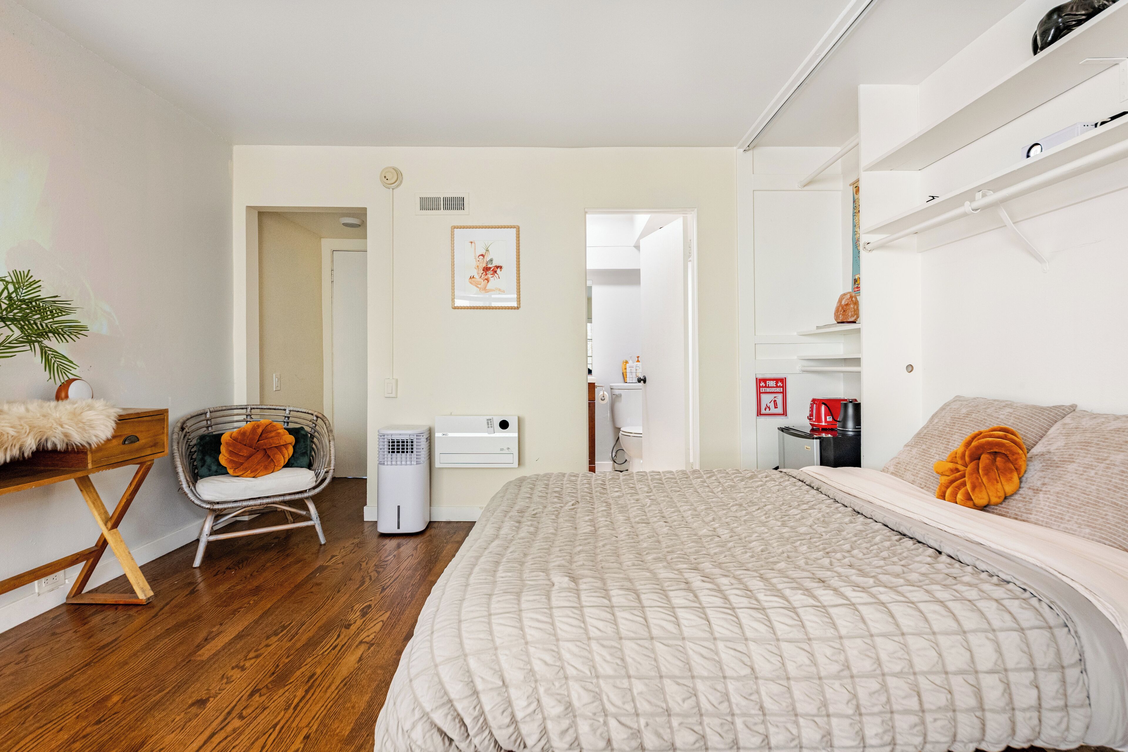 Ein Schlafzimmer mit Bett, Stuhl, Schreibtisch und Heizkörper.