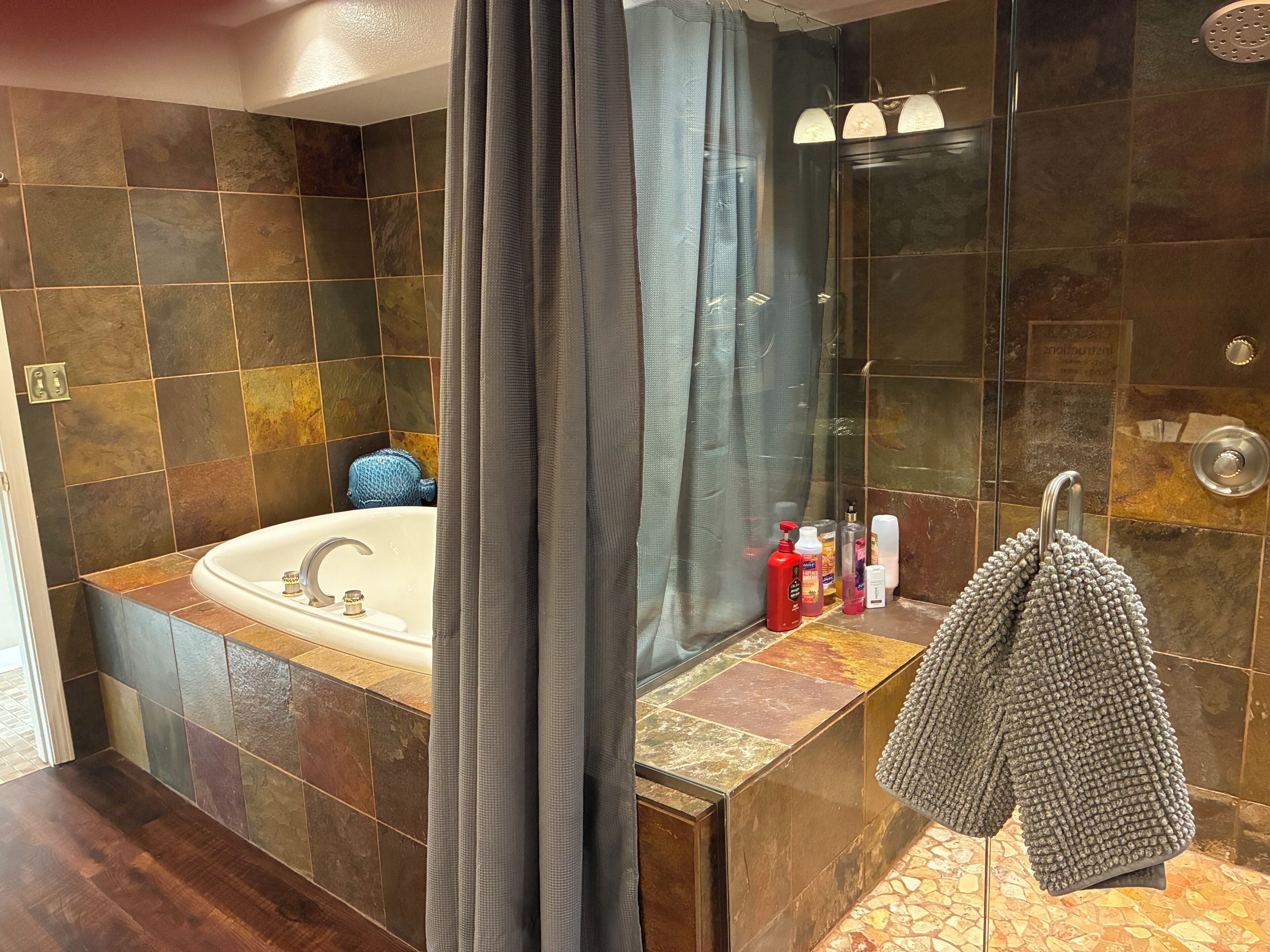 A bathroom with a bathtub, shower, and a towel rack.