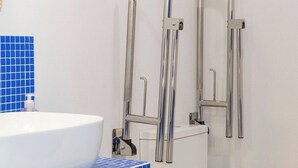 A bathroom with a white sink, blue-tiled countertop, and a white toilet. - Cabanyal Rooms by VLC Host 1 (Valencia)