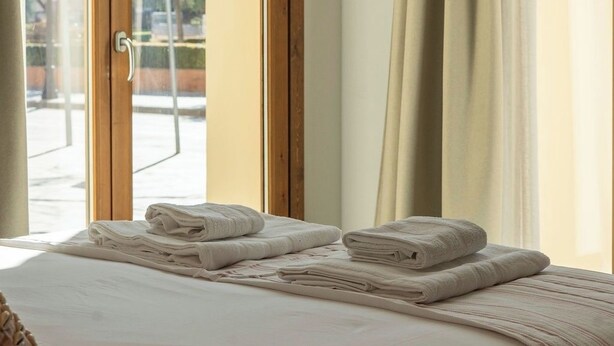 A hotel room with a bed, a window with curtains, and a view of the street outside. - Cabanyal Rooms by VLC Host 1 (Valencia)