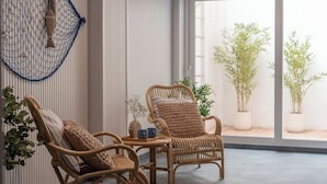A room with two wicker chairs, a small table, and potted plants. - Cabanyal Rooms by VLC Host 1 (Valencia)