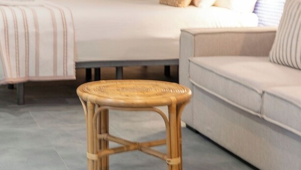 A hotel room with two beds, a wicker stool, a sofa, and a wall with decorative items. - Cabanyal Rooms by VLC Host 7 (Valencia)