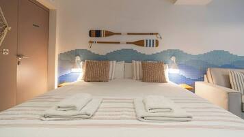 Een hotelkamer met een bed, twee kussens, een aan de muur bevestigd paddleboard en een deur met de tekst 'ALMACEN'.