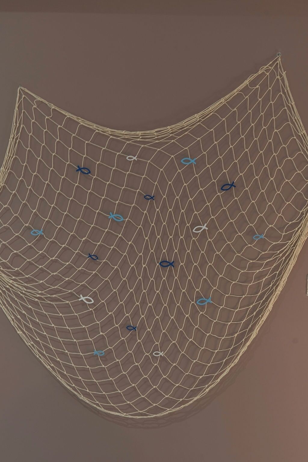 Une installation artistique géométrique composée d’une série de lignes interconnectées formant une figure incurvée.