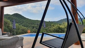 Ein überdachter Außenbereich mit Pool und Bergblick.