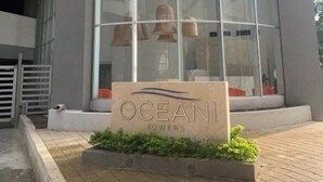A modern building with a curved glass facade and a sign that reads "OCEANI TOWERS UNIT". - Oceani Cartagena (La Boquilla)