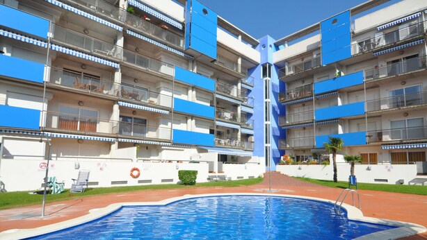 A swimming pool surrounded by a multi-story building with balconies. - Ground Floor Apt with Terrace & Pool Near Beach (ROSES)