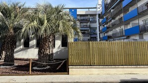 A modern building with multiple balconies and a wooden fence. - Ground Floor Apt with Terrace & Pool Near Beach (ROSES)