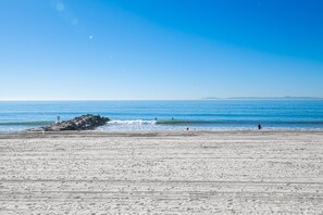 A beach with a rocky outcrop and waves. - 3BR Beachfront Home, Patio on the Sand w/ Gorgeous Ocean Views! (Newport Beach)