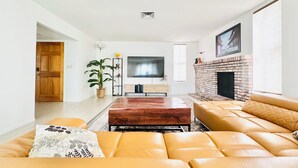 A modern living room with a large sofa set, a fireplace, a flat-screen TV, and a potted plant. - 5 mins to STRIP & LAS Airport, 3 King Bed 2.5 Bath, Peaceful & Clean (Las Vegas)
