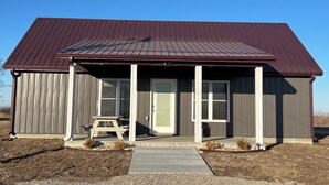 Un bâtiment d’un seul étage, doté d’un toit en métal foncé et d’un porche abrité.