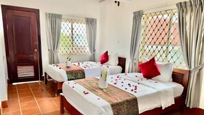 A hotel room with two beds, a wooden door, and windows with curtains. - SOMA Villa (Siem Reap)