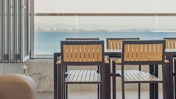 Una terraza con mobiliario exterior, una bicicleta y vista al mar.